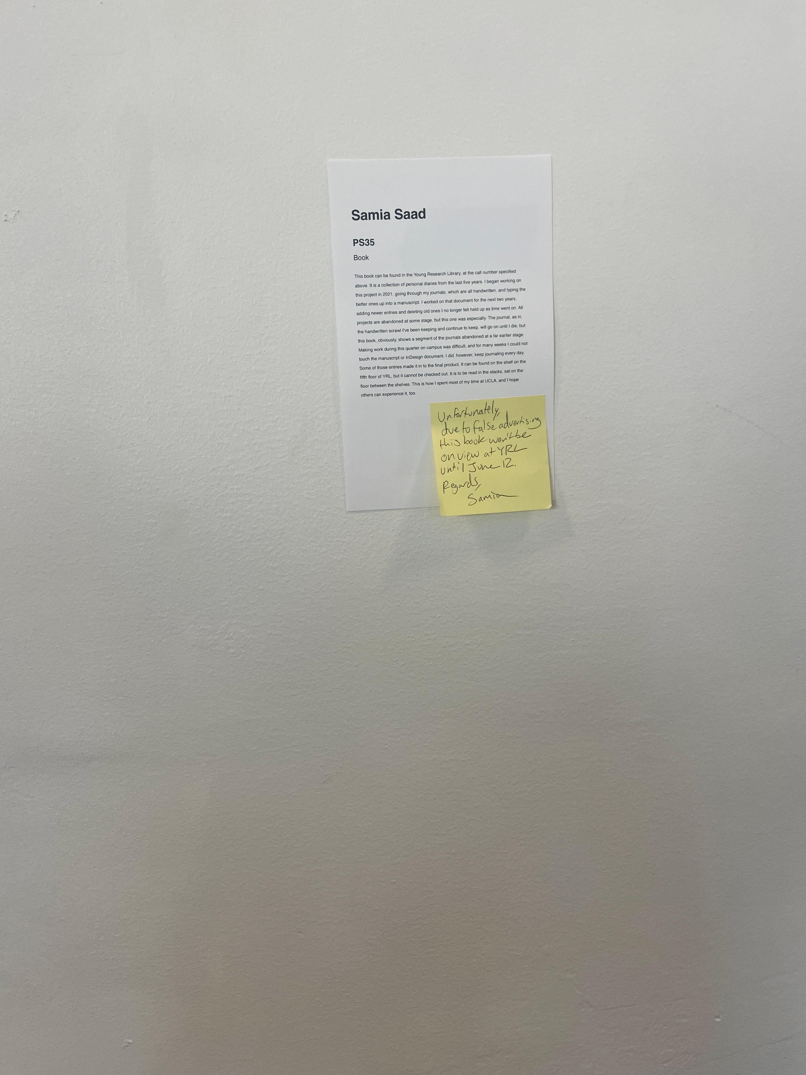 A yellow sticky note detailing that the work will not be shown till June 12 is attached to wall text